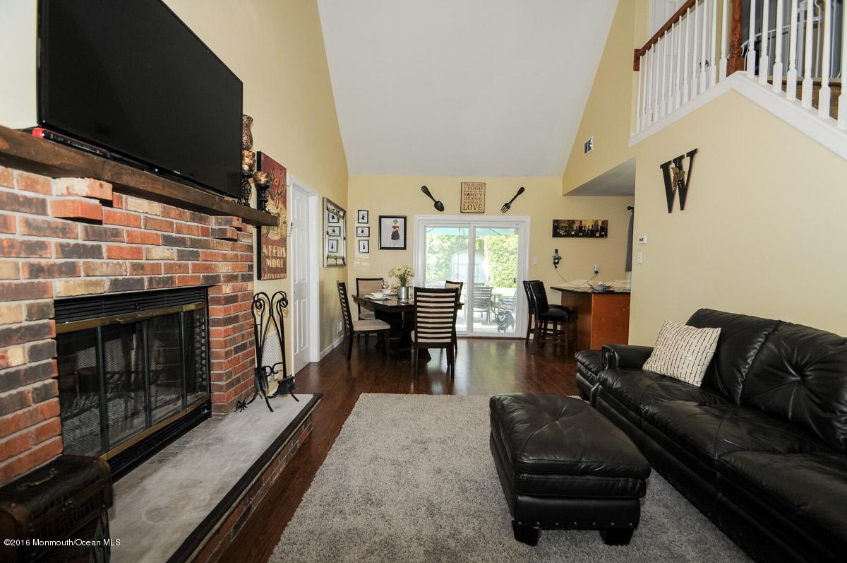 13 Valley Road Manalapan, NJ 07726 - Photo 8 of 26 a living room with furniture a flat screen tv and a fireplace