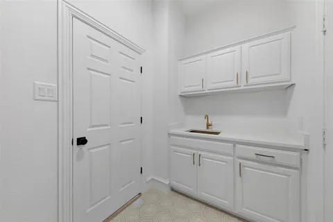 a kitchen with white cabinets and a sink