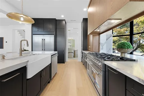 a large kitchen with a large window and stainless steel appliances