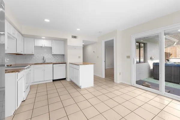 a kitchen with a sink a stove cabinets and utility room