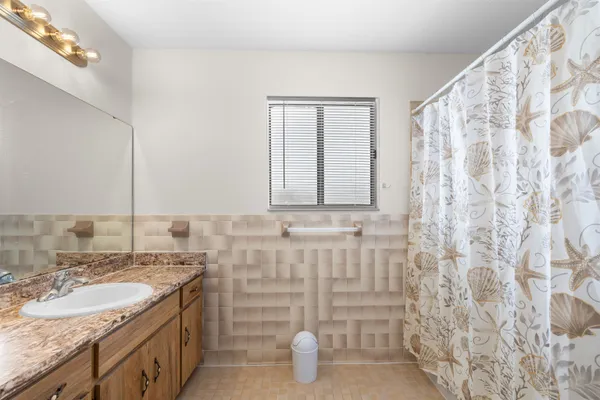 a bathroom with a granite countertop sink and a mirror