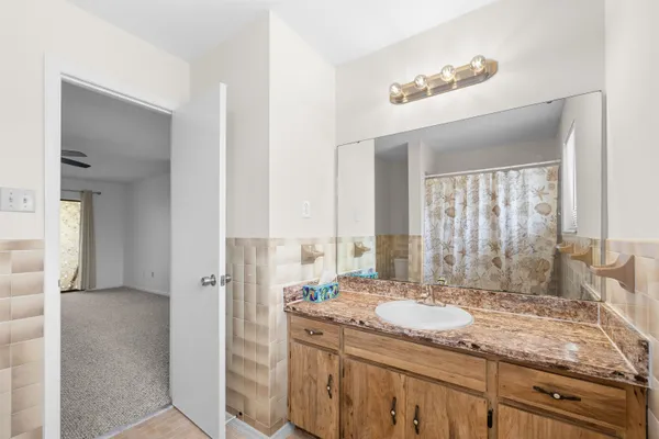 a bathroom with a granite countertop sink and a mirror