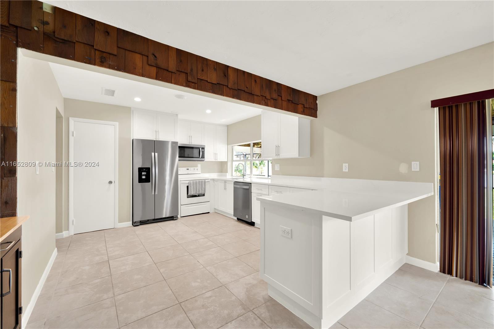 10962 Southwest 117th Street Miami, FL 33176 - Photo 25 of 42 a large white kitchen with a sink and refrigerator