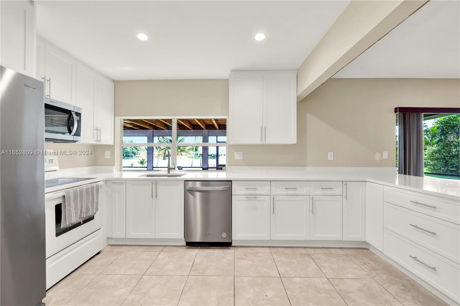 10962 Southwest 117th Street Miami, FL 33176 - Photo 28 of 42 a kitchen with granite countertop white cabinets and white appliances