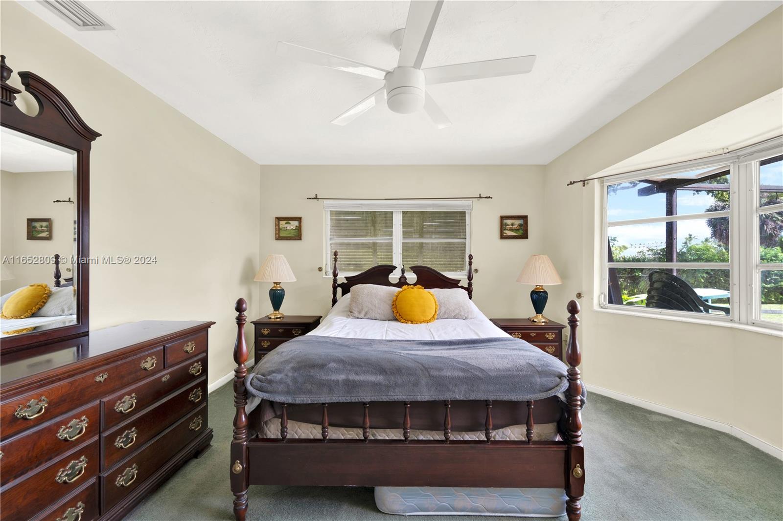 10962 Southwest 117th Street Miami, FL 33176 - Photo 30 of 42 a bed sitting in a bedroom next to a window with pc on the dresser