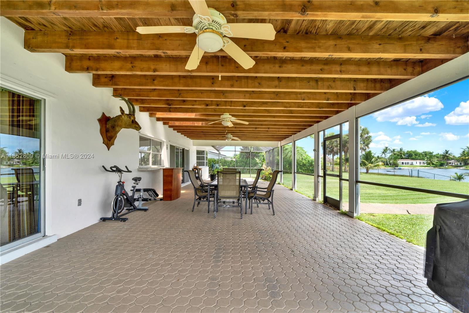 10962 Southwest 117th Street Miami, FL 33176 - Photo 33 of 42 a view of a patio with a table and chairs under an umbrella with a barbeque grill