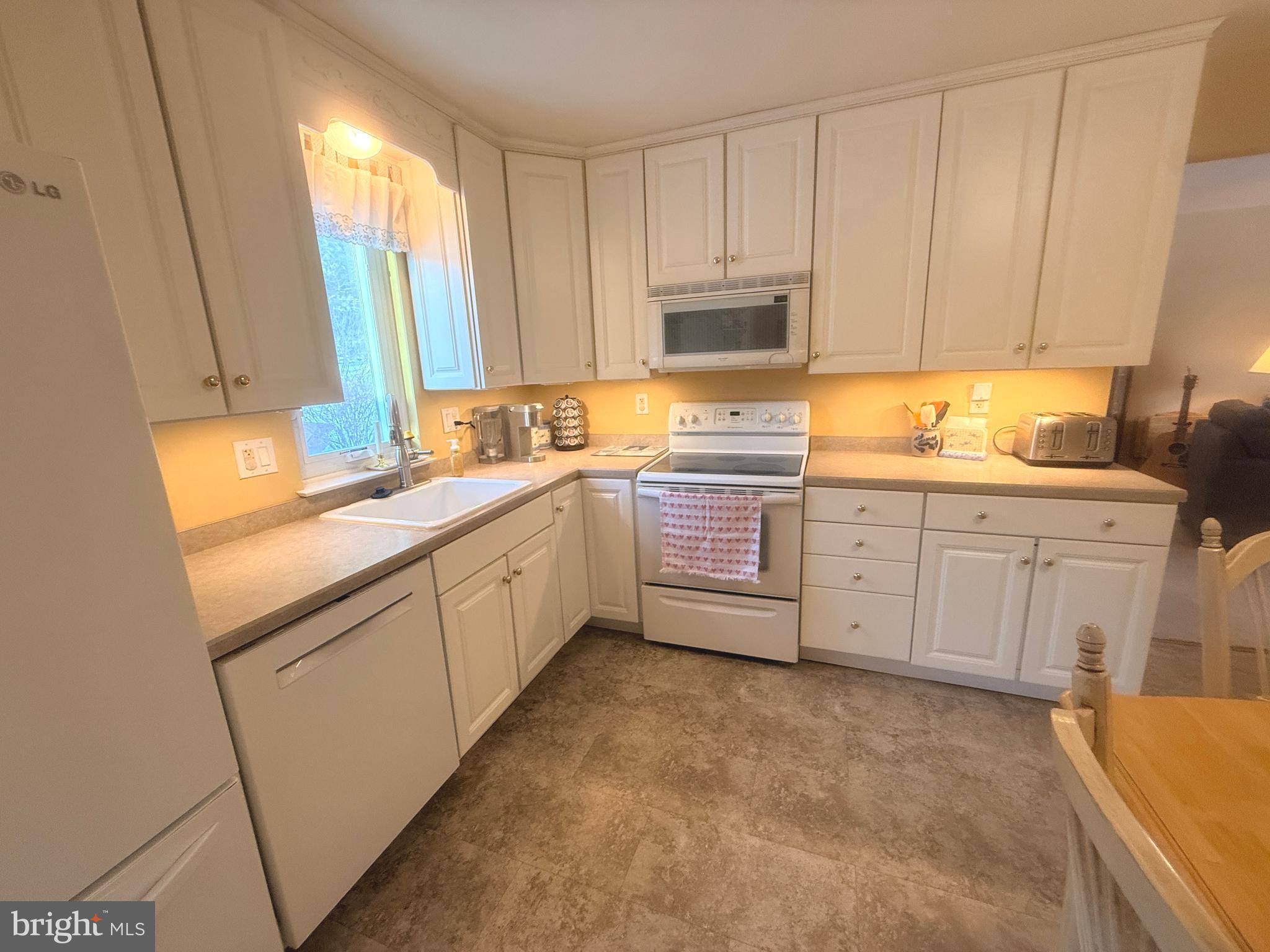 2343 Hancock Drive Lancaster, PA 17601 - Photo 13 of 41 a kitchen with stainless steel appliances granite countertop a sink a stove a refrigerator with white cabinets and wooden floor