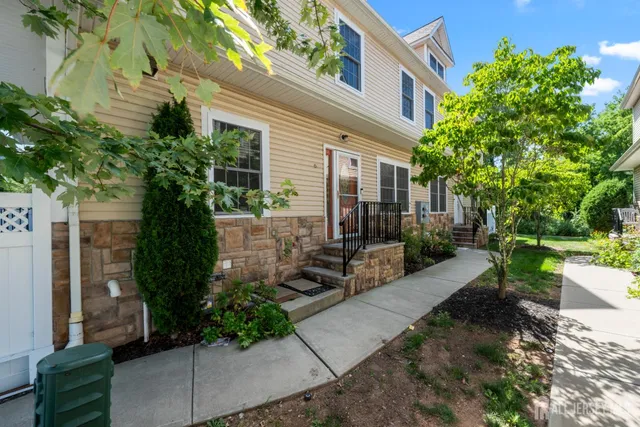 a view of a patio with table and chairs potted plants and large tree