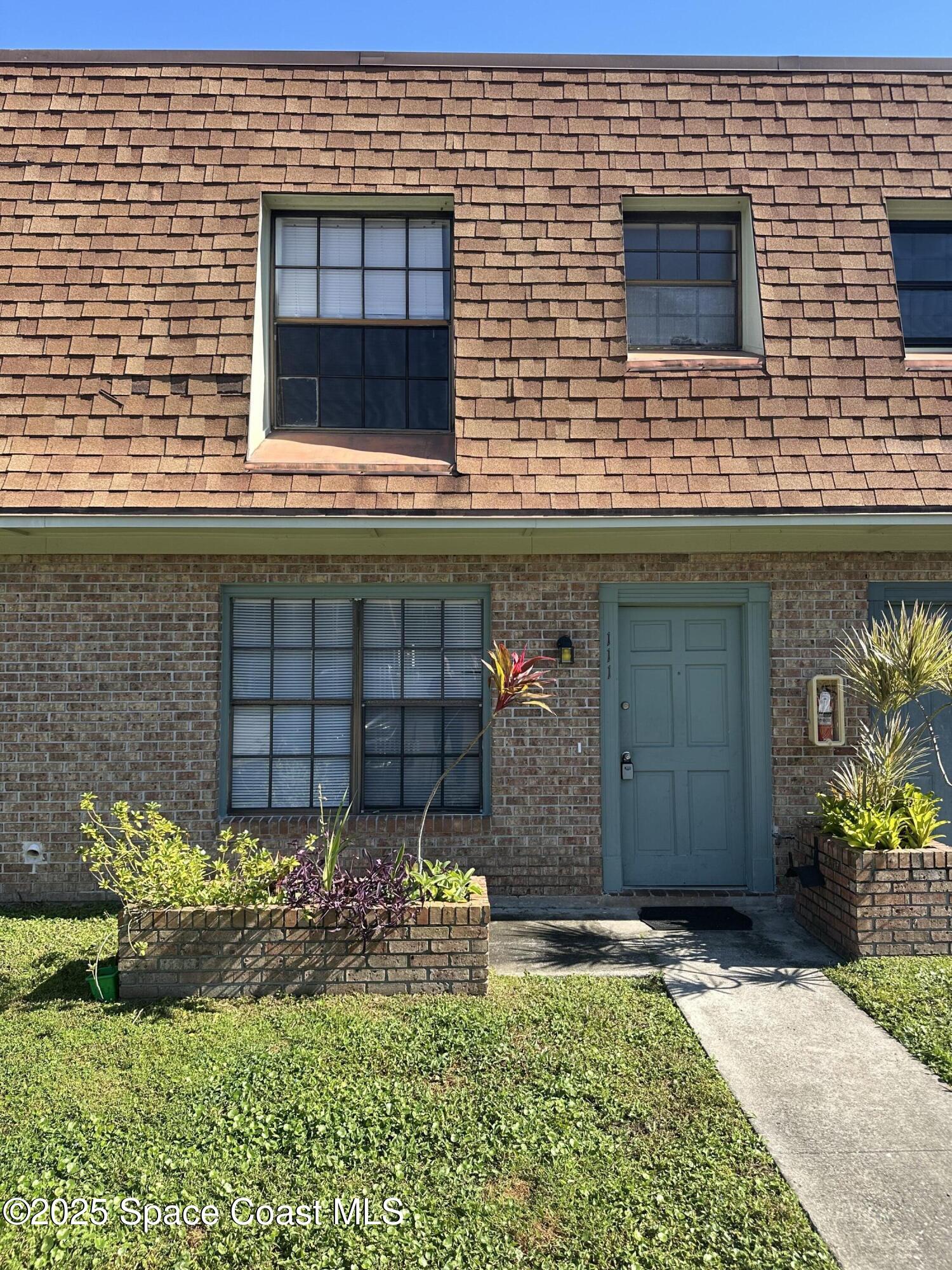 1301 Arlington Lane, Unit 111 Palm Bay, FL 32905 - Photo 1 of 18 a view of a brick house with a yard