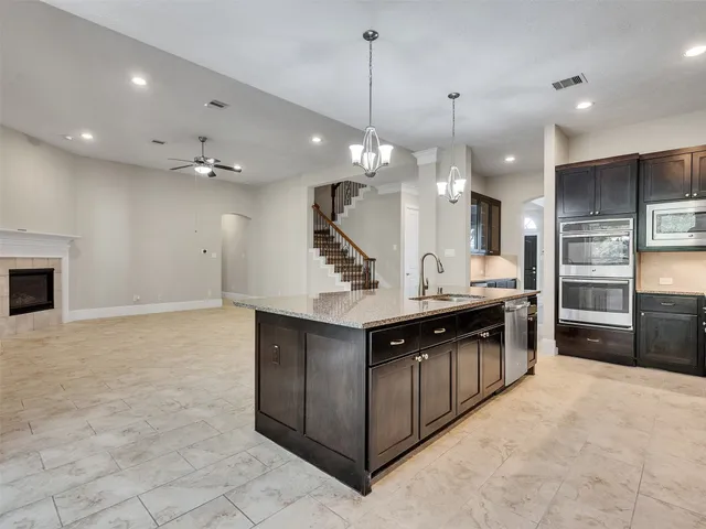 a kitchen with stainless steel appliances granite countertop a sink and a stove