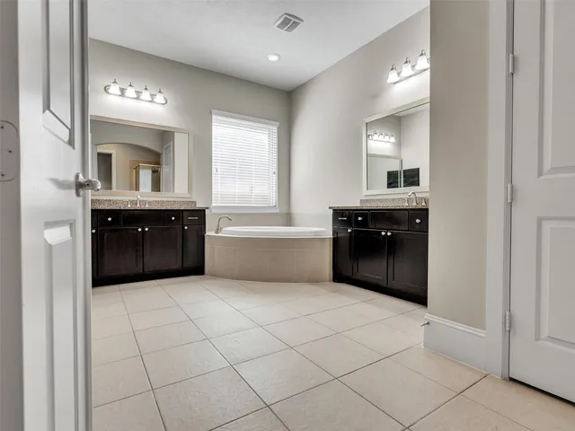 an empty room with wooden floor chandelier fan and windows