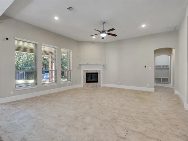 an empty room with windows and fireplace