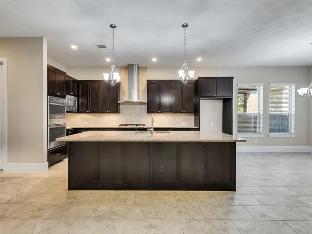 a large kitchen with kitchen island a sink stainless steel appliances and cabinets