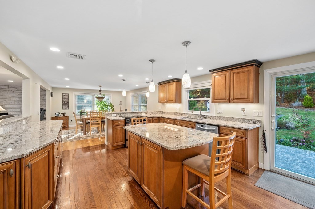 17 Mohawk Road Canton, MA 02021 - Photo 5 of 40 a kitchen with stainless steel appliances granite countertop wooden floor window dining table and chairs