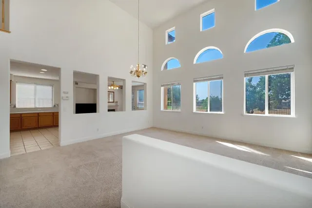 a view of a big room with windows and chandelier