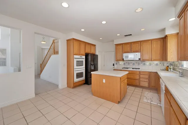 a kitchen with a sink a refrigerator and cabinets