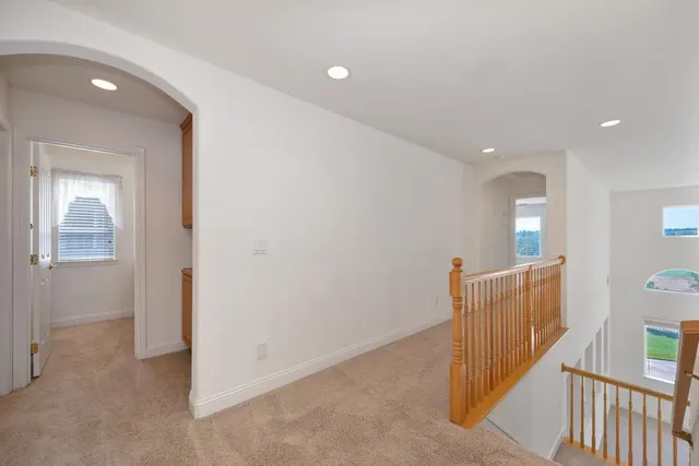 a view of an empty room and chandelier fan