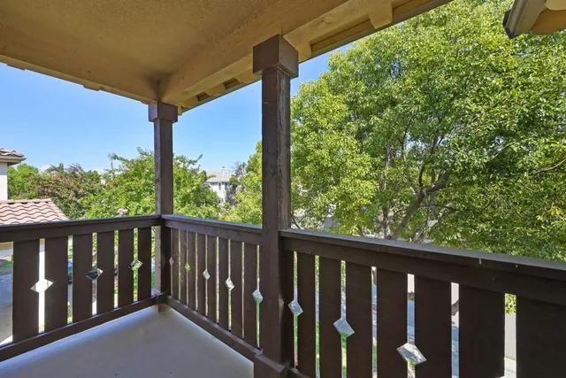 a spacious bedroom with a bed and a flat tv screen on a dresser