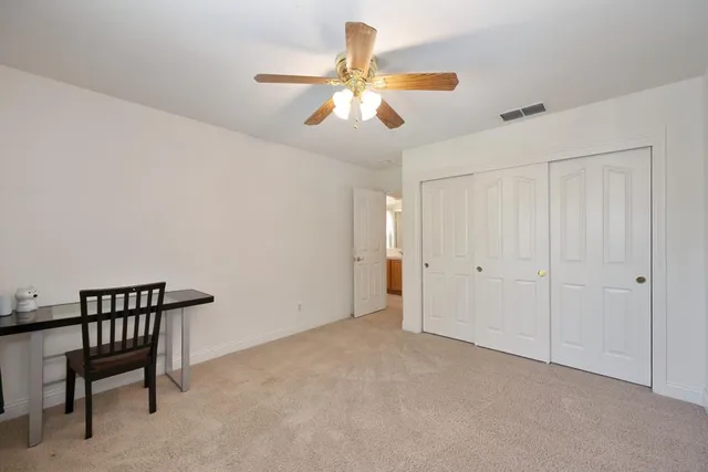 a spacious bedroom with a bed and a tv on dresser