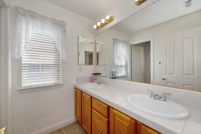 a spacious bathroom with a granite countertop sink and a mirror