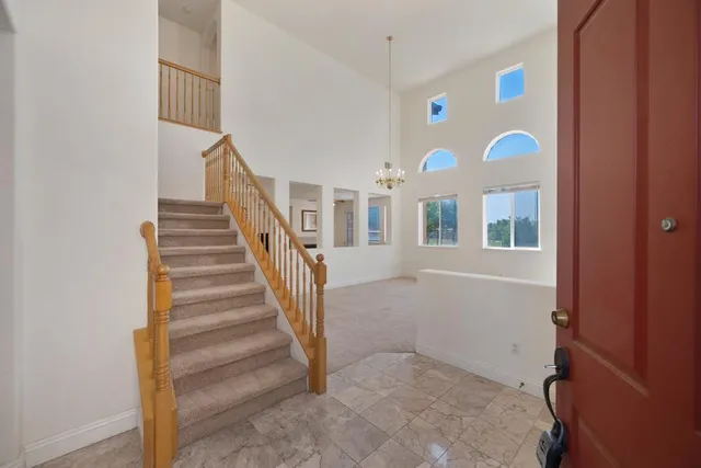 a view of a hallway with staircase and door