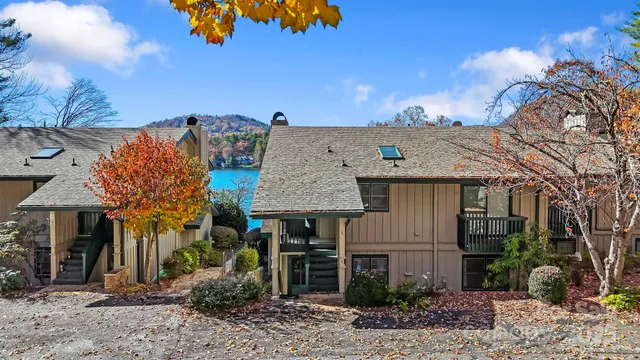 a view of a house with a backyard and a tree