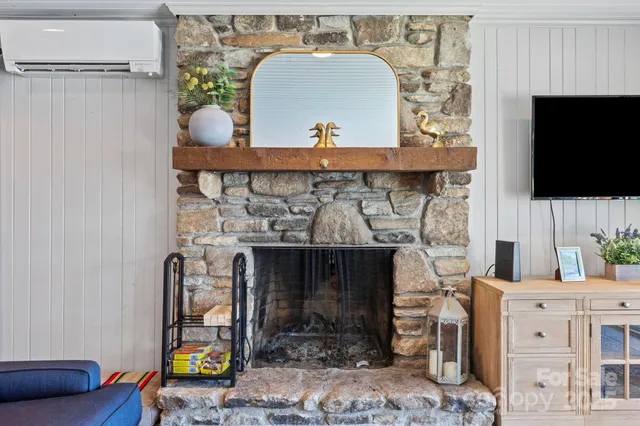 a living room with dining table and a refrigerator