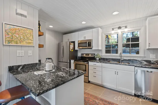 a kitchen with granite countertop stainless steel appliances a stove sink and microwave