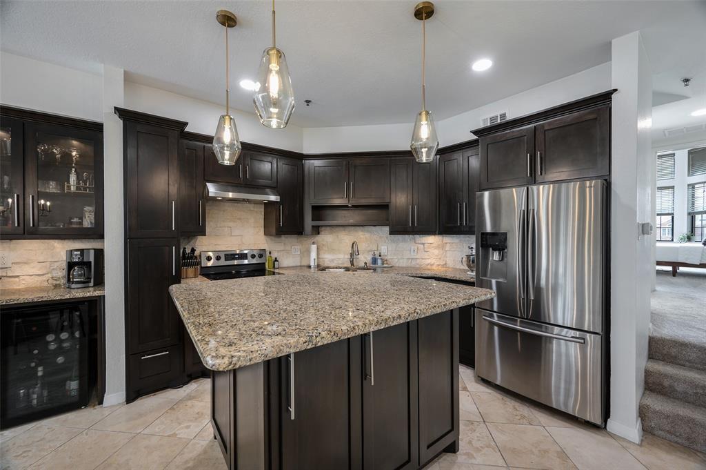 3235 Cole Avenue, Unit 75 Dallas, TX 75204 - Photo 1 of 1 a kitchen with stainless steel appliances granite countertop a refrigerator a sink and a refrigerator