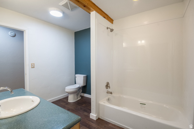 634 South 2100th Street West Vernal, UT 84078 - Photo 27 of 71 Bathroom featuring a white bathtub with a shower kit, a toilet, a vanity with an integrated sink and light blue countertop, and wood-finish flooring