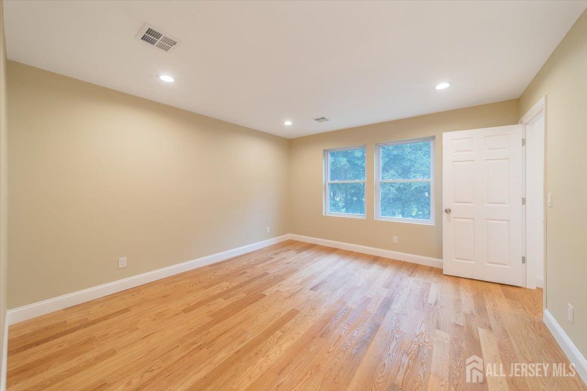 17 4th Street Hillsborough, NJ 08821 - Photo 13 of 33 a view of an empty room with wooden floor and a window