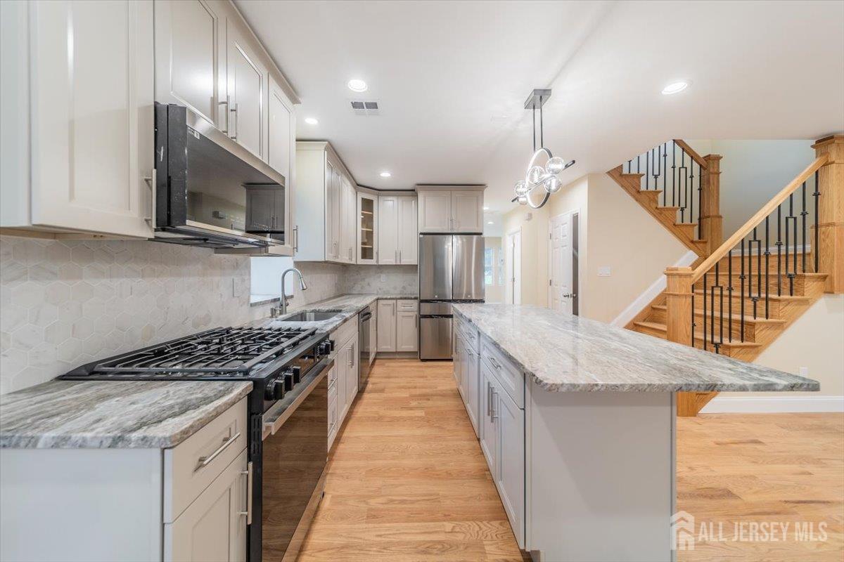 17 4th Street Hillsborough, NJ 08821 - Photo 2 of 33 a kitchen with stainless steel appliances kitchen island granite countertop a stove and a sink