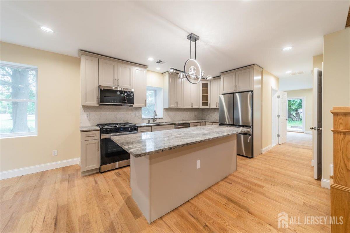 17 4th Street Hillsborough, NJ 08821 - Photo 3 of 33 a large kitchen with stainless steel appliances kitchen island granite countertop a refrigerator a stove and a sink