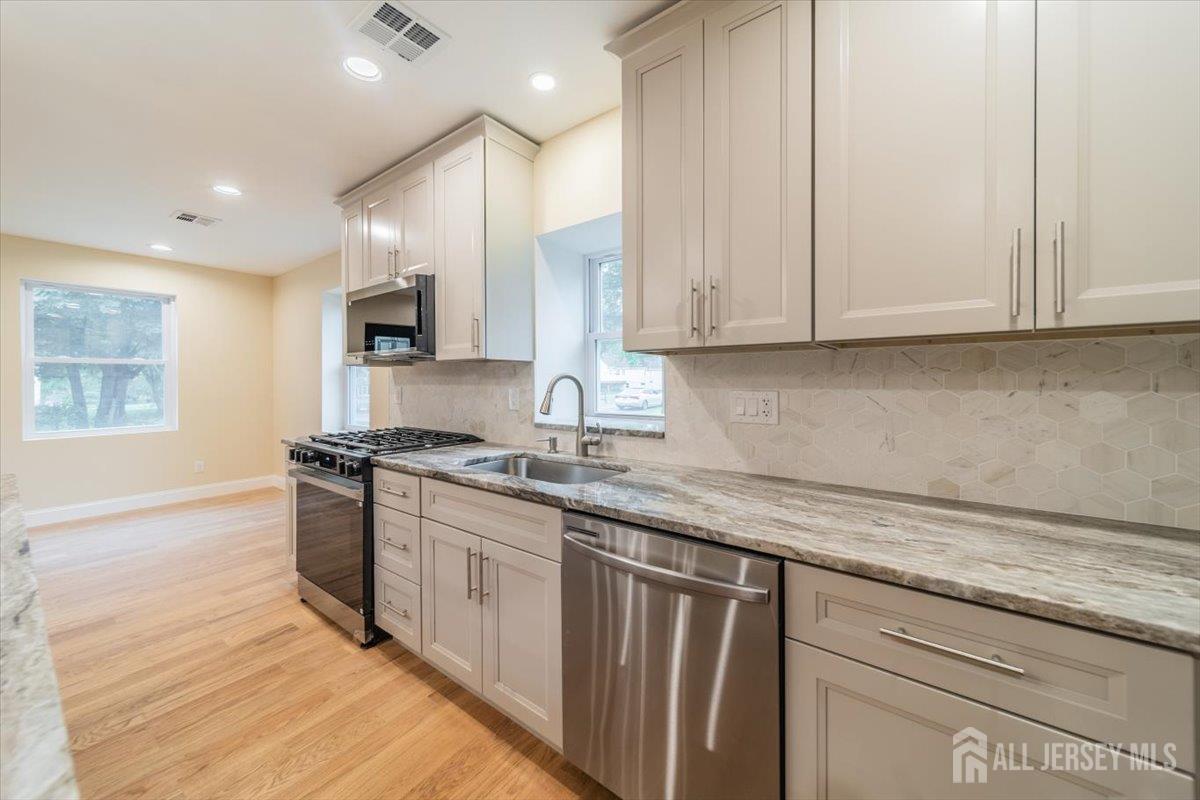 17 4th Street Hillsborough, NJ 08821 - Photo 5 of 33 a kitchen with stainless steel appliances granite countertop a sink stove and cabinets