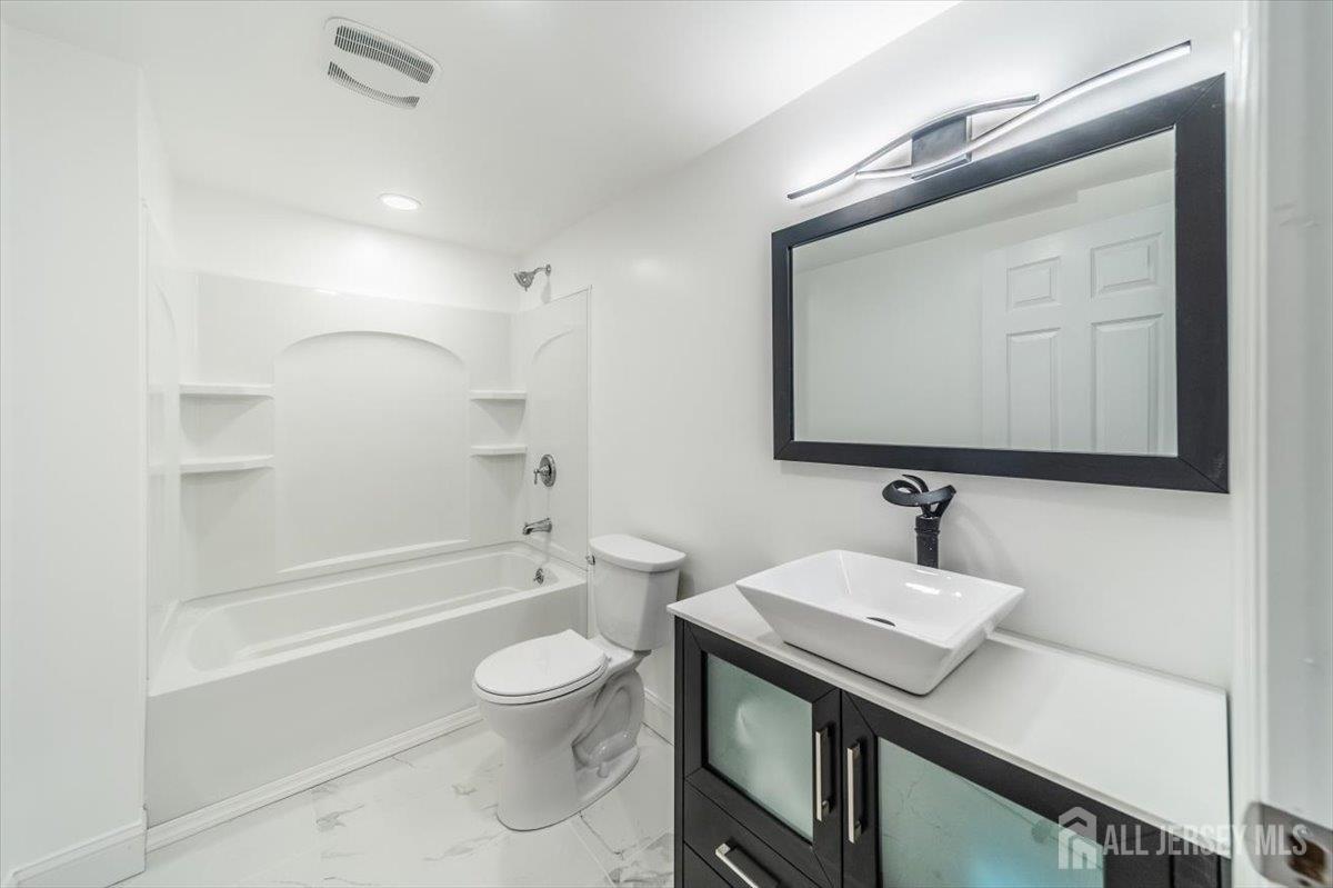 17 4th Street Hillsborough, NJ 08821 - Photo 8 of 33 a bathroom with a sink a toilet and a mirror