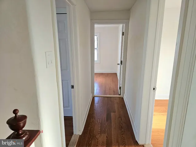 a view of a hallway with wooden floor and closet