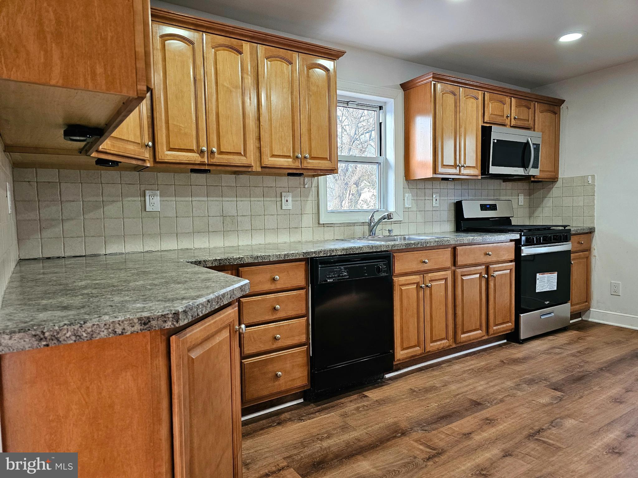 332 East Linden Avenue Lindenwold, NJ 08021 - Photo 3 of 25 a kitchen with stainless steel appliances granite countertop wooden cabinets and a stove top oven