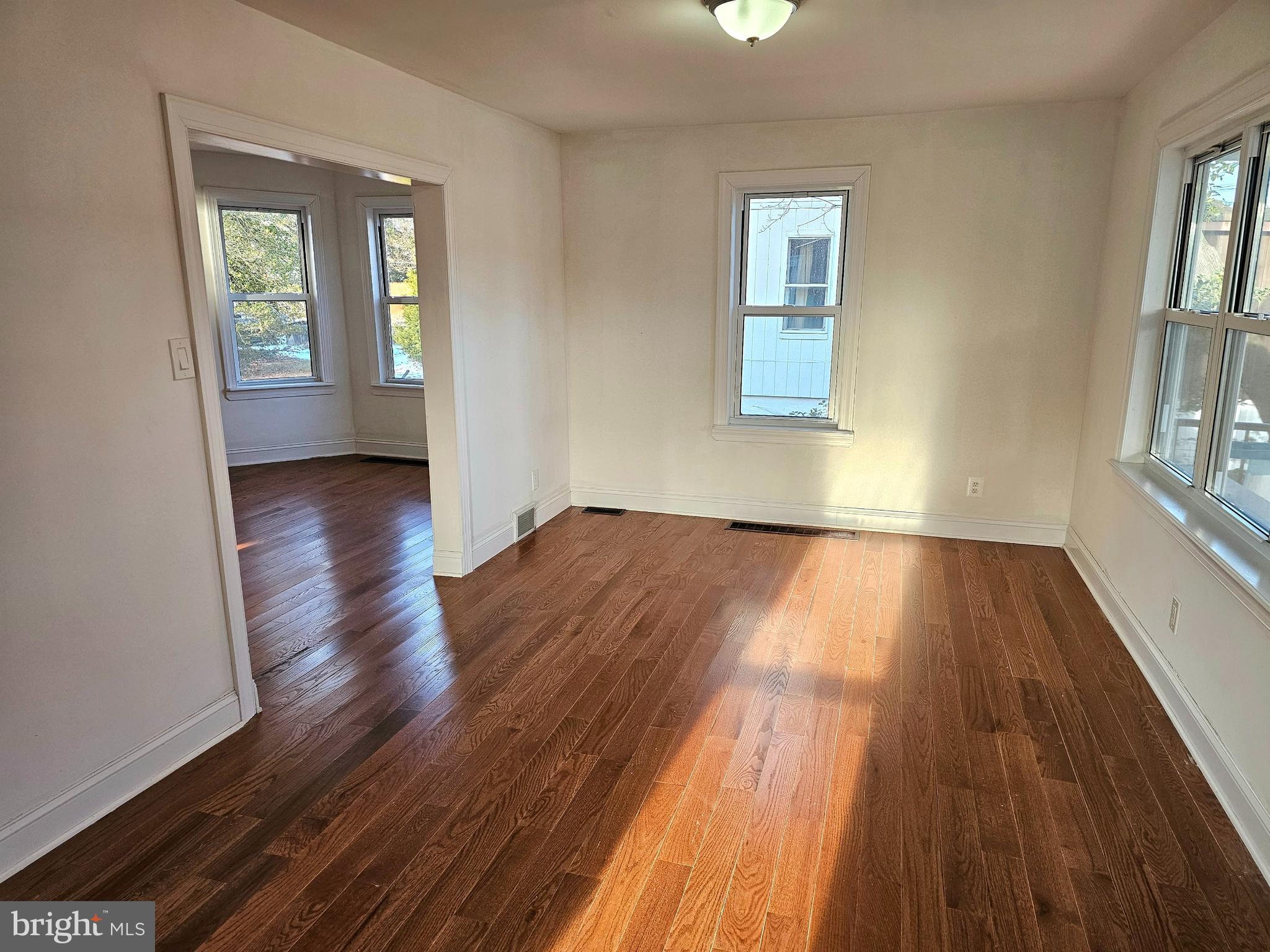 332 East Linden Avenue Lindenwold, NJ 08021 - Photo 5 of 25 an empty room with wooden floor and windows