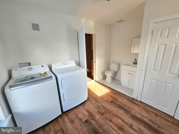 a utility room with wooden floor washer and dryer