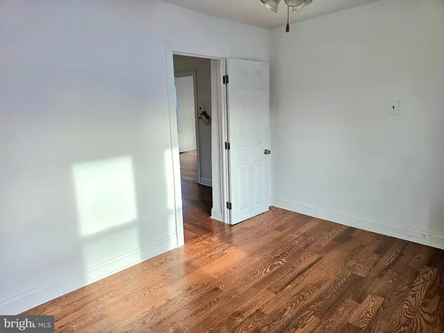 an empty room with wooden floor and a window