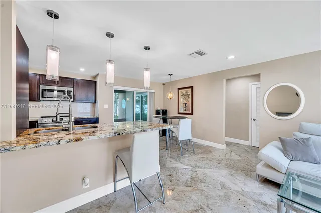 a open kitchen with stainless steel appliances kitchen island granite countertop a sink and cabinets