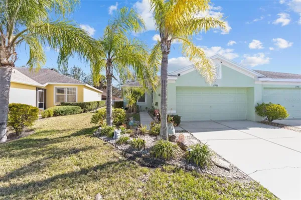 a view of backyard of white apartments with palm trees