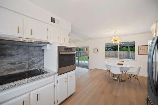 a kitchen with granite countertop a sink and a stove top oven