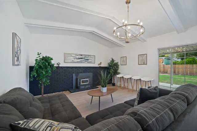 a living room with furniture a fireplace and a floor to ceiling window