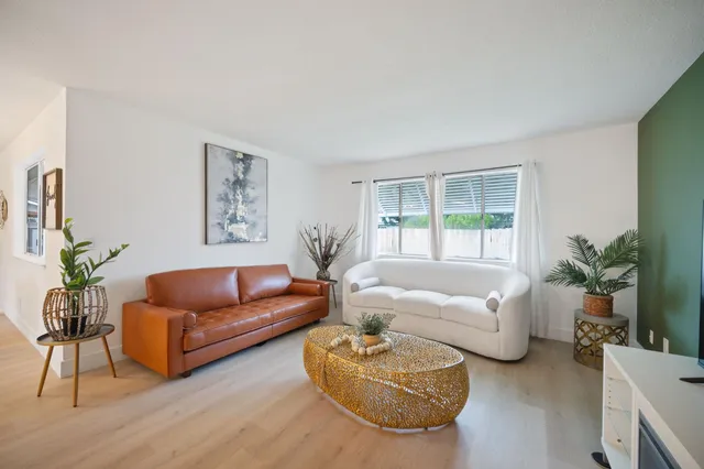 a living room with furniture potted plant and a window