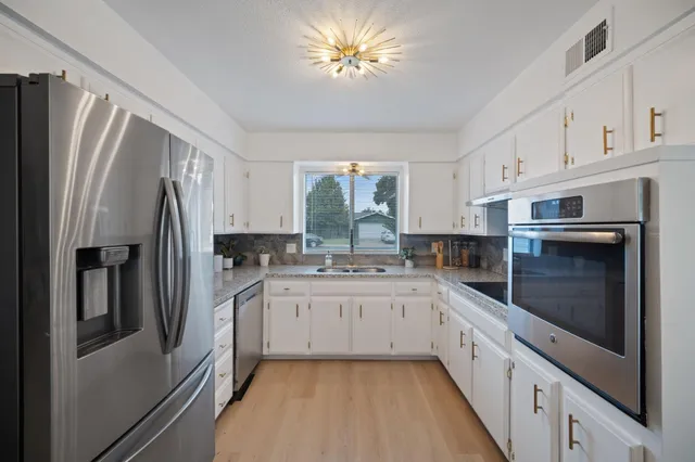 a kitchen with stainless steel appliances a refrigerator sink and cabinets