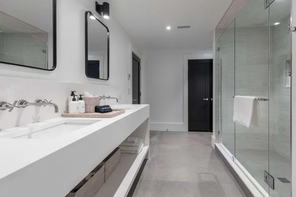a bathroom with a double vanity sink mirror and shower