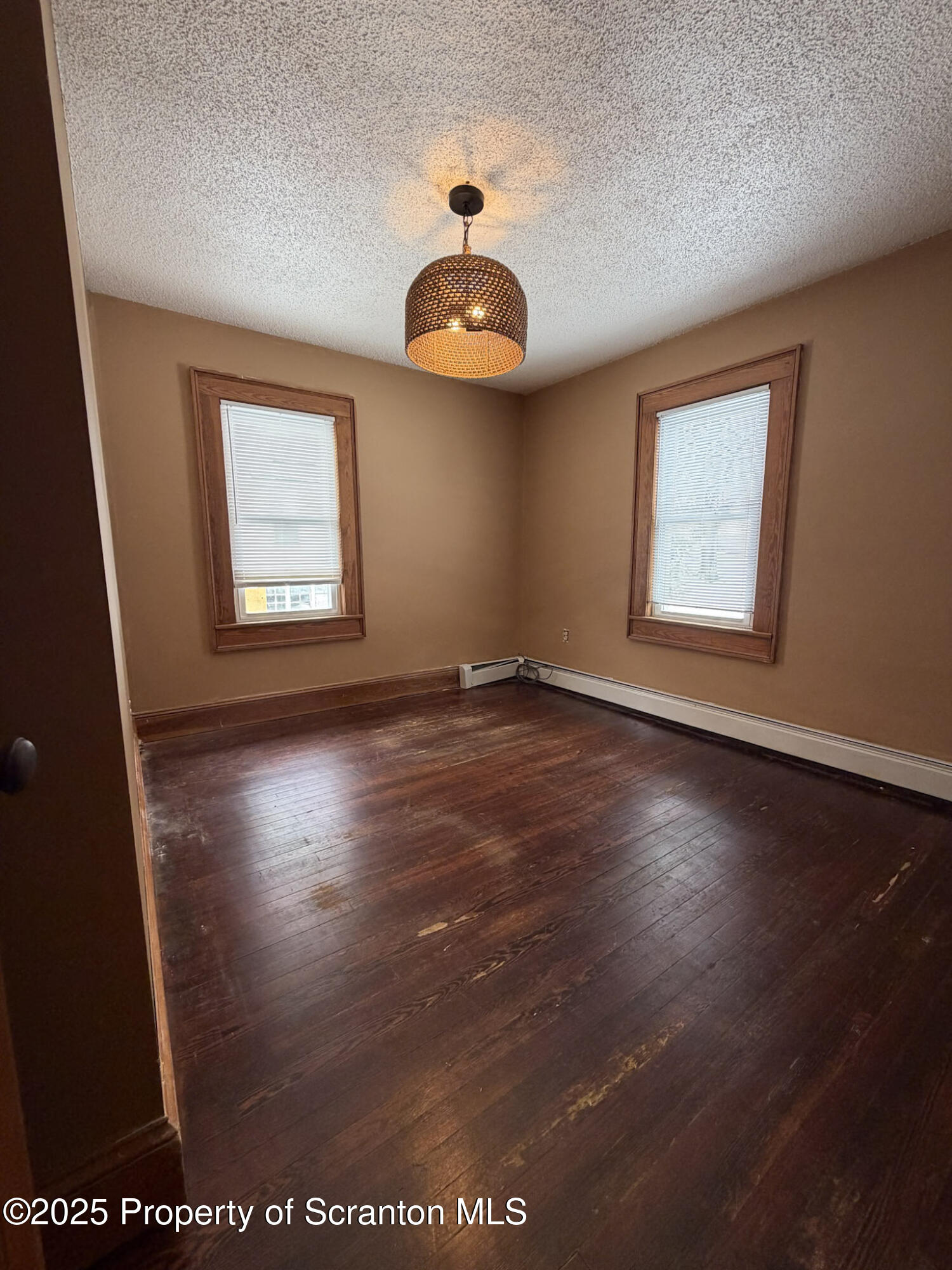 316 Bridge Street Blakely, PA 18452 - Photo 31 of 39 an empty room with wooden floor and windows