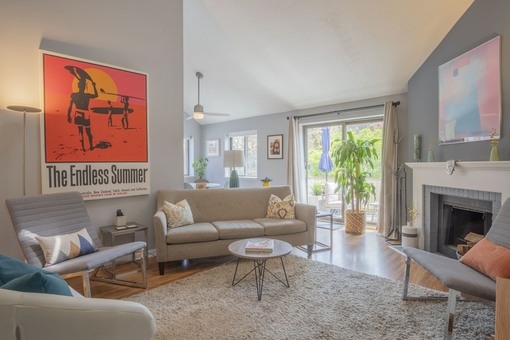 a living room with furniture a fireplace and a large window