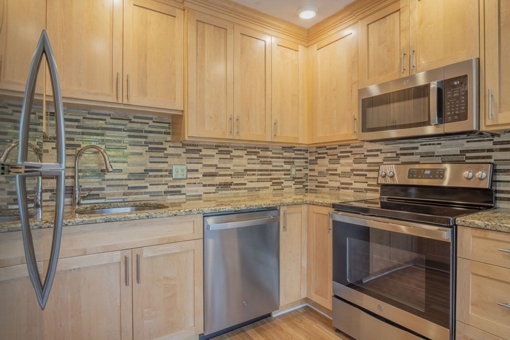 9 Barton Square, Unit 201 Salem, MA 01970 - Photo 14 of 42 a kitchen with stainless steel appliances granite countertop a stove microwave and cabinets